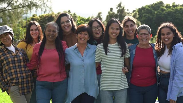 Group of multi generational women hugging each other while smiling on camera - Diverse women concept	