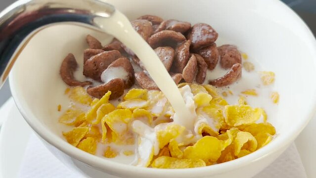 Healthy Breakfast Concept - Adding hot milk to a mixture of Cereal and Chocos
