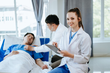 Fototapeta premium Doctor using digital tablet and chart with colleagues and patient behind in a hospital .