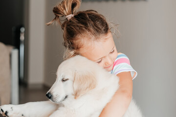 child girl play hugging dog puppy golden retriever, pet therapy and canisterapy for adults and children. animal canis assisted therapy. kids emotion mental health friends love tightly cuddle