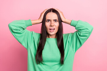 Photo of terrified horrified woman with straight hair dressed green sweatshirt hold arms on head isolated on pink color background - obrazy, fototapety, plakaty