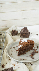 Flourless chocolate almond layer cake with powedered sugar decoration on top white wooden background close up selective focus