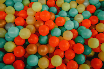 Multi-colored plastic balls in children's attraction. Funny pool, top view.