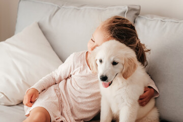 child girl play hugging dog puppy golden retriever, pet therapy and canisterapy for adults and children. animal canis assisted therapy. kids emotion mental health friends love tightly cuddle