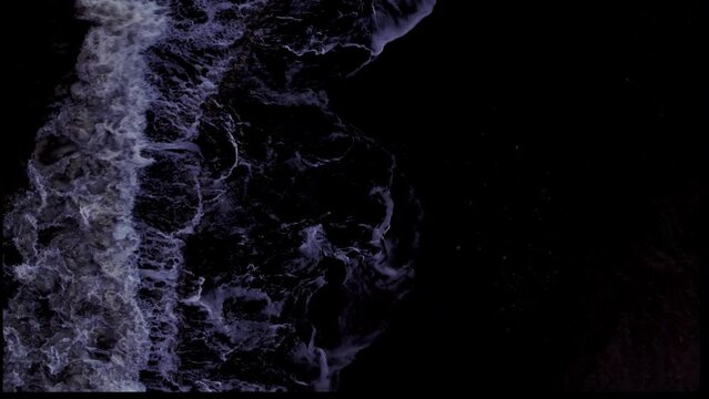 una ola sobre fondo negro que ocupa el lado izquierdo de la pantalla