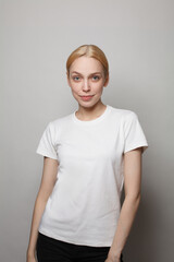 Portrait of young blonde woman in white empty t-shirt posing