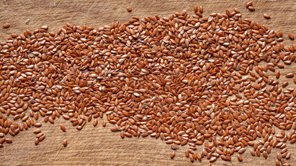 Obraz premium Flax seeds. Flax seeds are scattered on a wooden board. Omega 3. Healthy nutrition