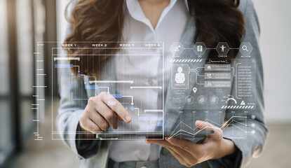 Business woman hand Project manager working and update tasks and Gantt chart scheduling virtual diagram.with tablet in office.