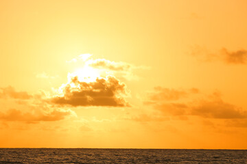 Fototapeta na wymiar sunrise at seaside with small cloud in golden sky
