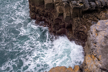 White waves on a blue Irish rocky cliff in a blue sky dasy