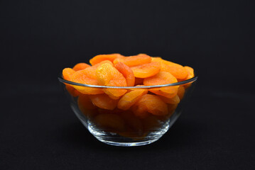 Juicy dried apricots in a glass bowl. Dried apricot fruit halves without a stone.