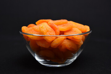 Juicy dried apricots in a glass bowl. Dried apricot fruit halves without a stone.