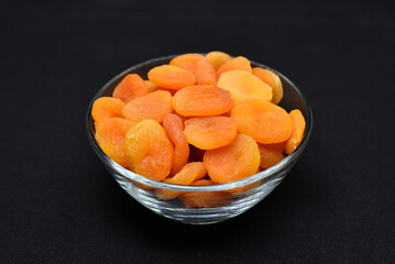 Juicy dried apricots in a white ceramic bowl. Dried apricot fruit halves without a stone.