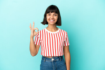 Young mixed race woman isolated on blue background showing ok sign with fingers