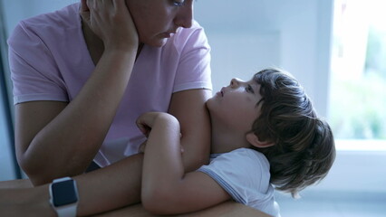 Small boy leaning on mother arm wanting attention. Little boy and parent relationship. Kid leans on...