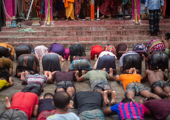 People showing salutations by falling prostrate before goddess durga in an religious festival for...
