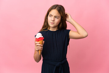 Child with a cornet ice cream over isolated pink background having doubts