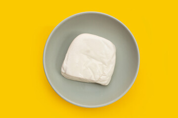 White tofu in plate on yellow background