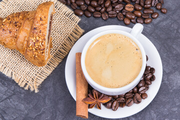 Coffee in cup and roasted dark coffee beans with anise and cinnamon