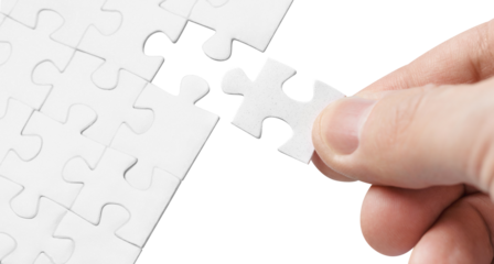 Hand inserting missing piece of puzzle, cut out