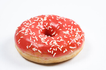 Large doughnut with red glaze and sprinkled on a white background of isolate