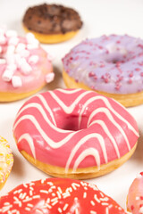 Donuts with red and pink glaze, top view. Lots of donuts, sweet and delicious food