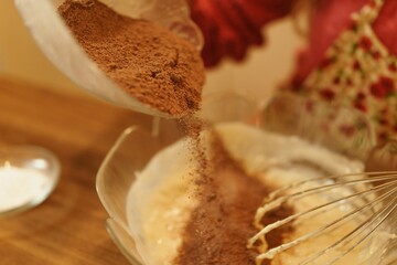 Close-up view of adding cocoa powder to the pastry dough. The moment of spilling the cocoa powder while making the cookie dough.