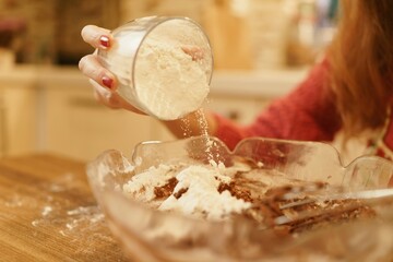 Close-up view of adding flour to pastry dough. The moment when the flour is poured while the cookie dough is being prepared.
