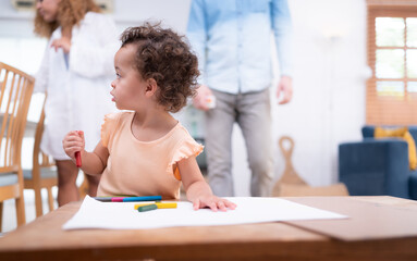 A little child's imagination is represented through colored pencil drawings, with the mother attentively supervising in the living room of the house.