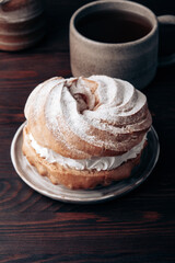 Choux Pastry Ring on brown wooden table. Sweet dessert for coffee break or party.