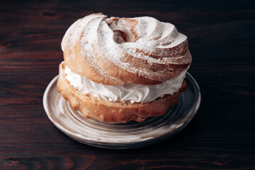 Choux Pastry Ring on brown wooden table. Sweet dessert for coffee break or party.