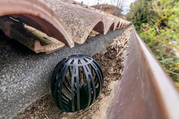 Plastic ball to protect the gutter from leaves, moss, manure, mud and other debris, placed on a...