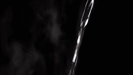 Jet of Hot Boiling Water a Pouring on the Background of Clouds White Steam. Evaporation of steam on a black background. A falling transparent jet of hot water. Splash, drops. Vapor cloud. Blurred fog. - Powered by Adobe