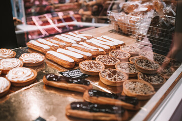 a display case filled with lots of different types of cakes and pies on display in a bakery or deli or bakery shop front view of cakes and frosted with frosting on the shelves. Selective Focus. High