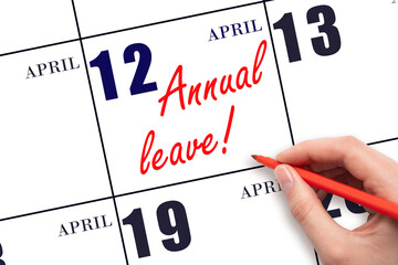 Hand writing the text ANNUAL LEAVE and drawing the sun on the calendar date April 12