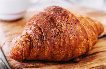croissant with chocolate powder on a wooden board