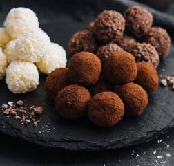three types of chocolate balls on stone board