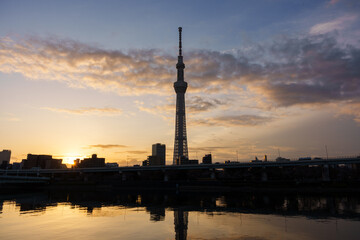 東京スカイツリーの側から昇る朝日と朝焼けの空と隅田川