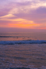 Surfers catch waves, surfing at sunset. Bali.