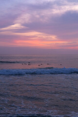 Surfers catch waves, surfing at sunset. Bali.