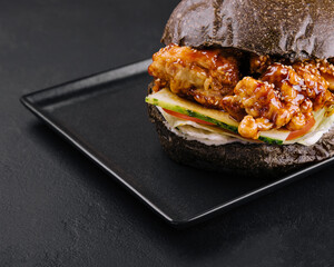 burgers with fried chicken strips on black tray