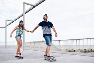 Couple skateboarding together.