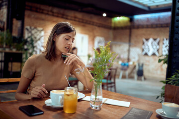 Young woman enjoying her time in coffee shop. Taking notes, writing something.