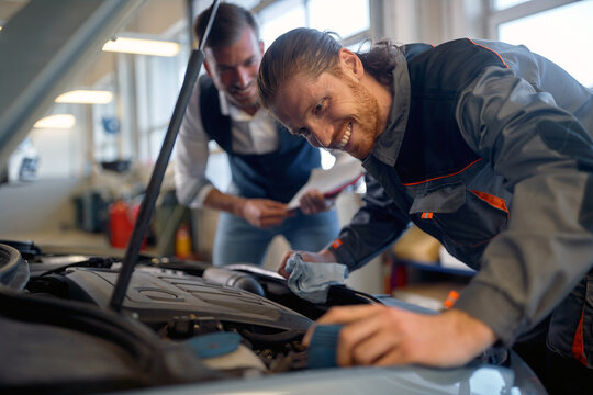 Two technicians doing car diagnostics together