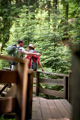 A young happy couple enjoying a walk on the forest path in the mountain. Trip, nature, hiking