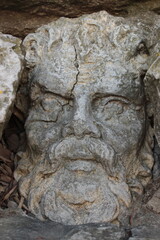Ancient stone Roman face carved into wall in Nimes, France