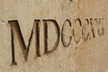 macro ancient roman numerals etched in stone (Maison Carrée, Nimes, France)