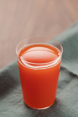 Organic grapefruit juice in tumbler glass on linen napkin