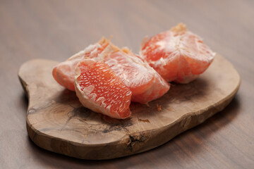 Peeled grapefruit on olive serving board