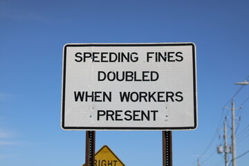 A generic speeding sign reading speeding fines doubled when workers present. No designer mark or...